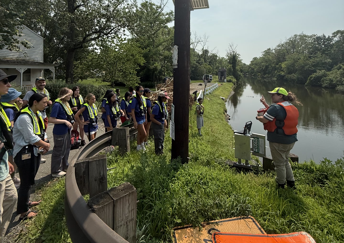 Watershed Academy students learning about field hydrology beside a stream